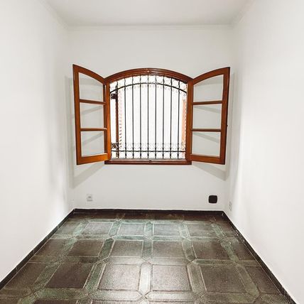 Estado atual de um quarto compacto com janela arqueada