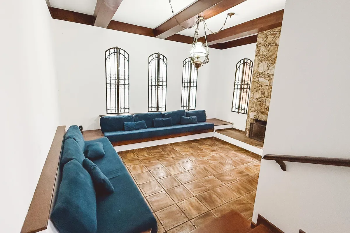 Sala ampla com janelas arqueadas, pedra e madeira